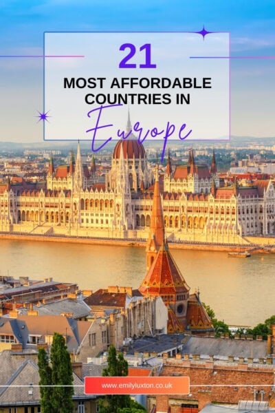 Cover image for pinterest. The text reads "21 Most Affordable Countries in Europe" written over an opaque white box on top of a photo of a city skyline with a wide river and a large white palace with a red roof. 