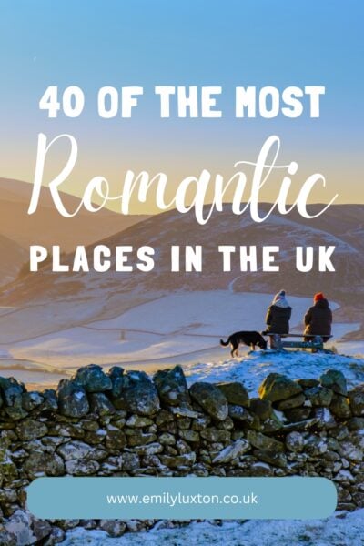 40 of the Most Romantic Places in the UK: written in white text above an image of a snowy landscape in the peak distrcit with a couple sat on a bench next to a black dog. 