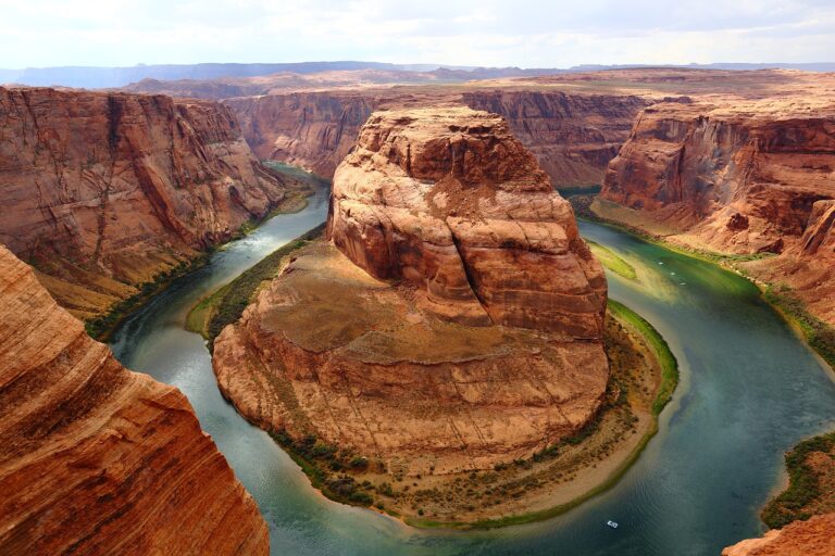 aerial view of horseshoe bend in the grand canyon, a river in a semi circle around a large red rock in the canyon