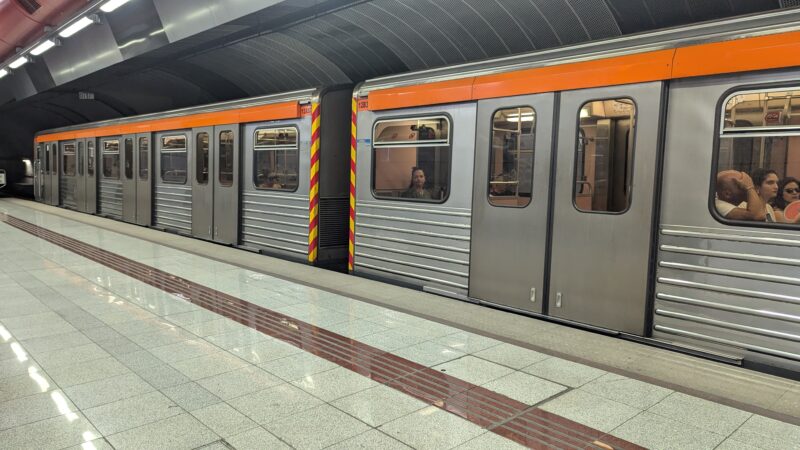 grey metal train at an underground station with marble floors in Athens