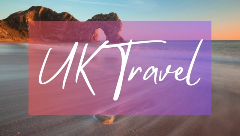 UK Travel written in white text over an opaque pink box on top of a photo of Durdle Door, a rock arch over the sea. It is just after sunset and the sky is orange. 