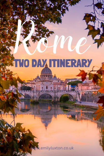 Text reading: Rome Two Day Itinerary. This title is printed on top of a photo of a river with the domed basilica of the vatican city on the far side refelected in the water at dusk with purple sky, and the view is framed by leaves. 