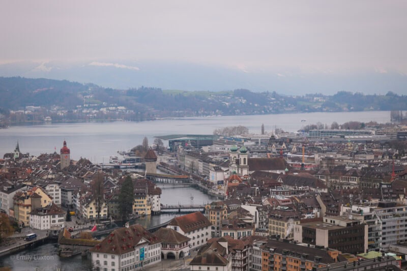 View of Lucerne city centre and the neighbouring lake from a hilltop on a grey overcast day in winter.