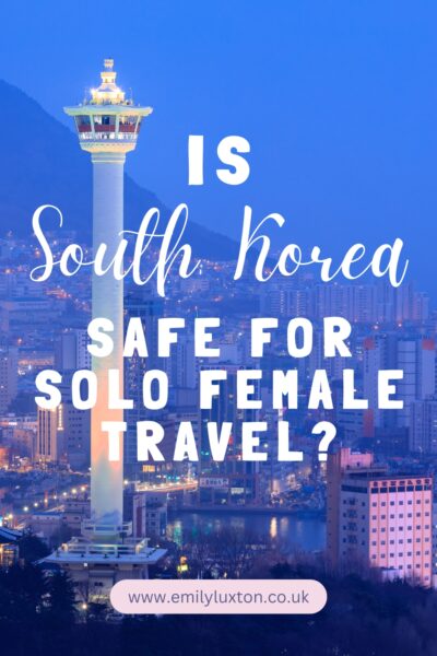 A nighttime cityscape of Busan, South Korea, featuring the illuminated Busan Tower. The text overlaid on the image reads: "Is South Korea safe for solo female travel?"