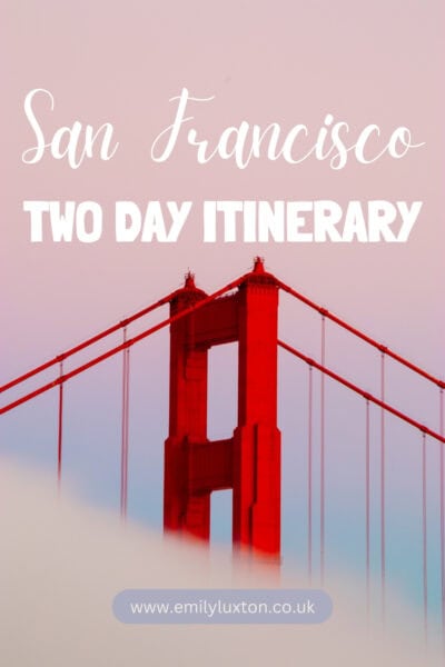 San Francisco Two Day Itinerary: written in white text over a photo showing the top of a red metal arch on the Golden Gate bridge against a pink sunset sky.